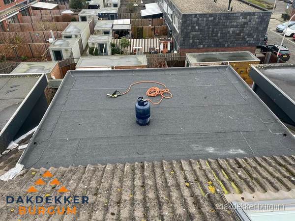 Plat dak met nieuwe bitumen dakbedekking en brandgereedschap in Burgum