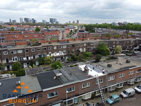 Spoed dakdekker aan het werk op plat dak in woonwijk Burgum