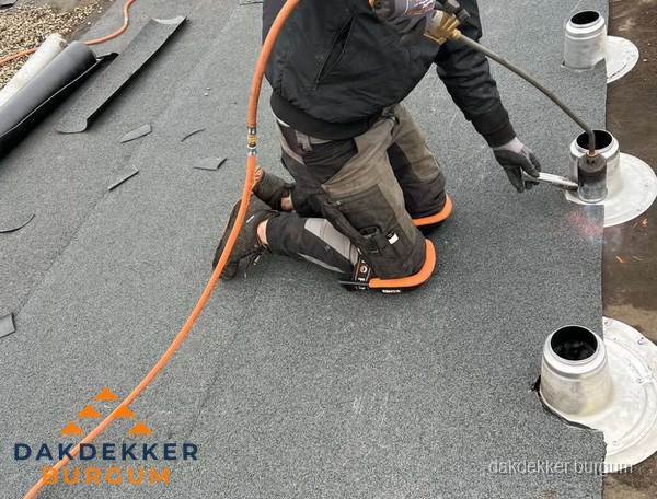 Dakdekker repareert bitumen dakleer bij dakdoorvoer in Burgum