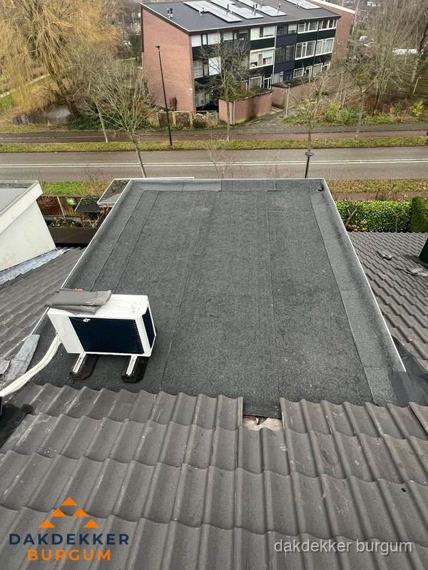 Plat dak inspectie met bitumen bedekking naast schuin pannendak in Burgum Plat dak inspectie met bitumen bedekking naast schuin pannendak in Burgum