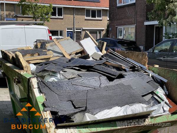 Afvalcontainer met gesloopt dakmateriaal tijdens dakkapel renovatie in Burgum