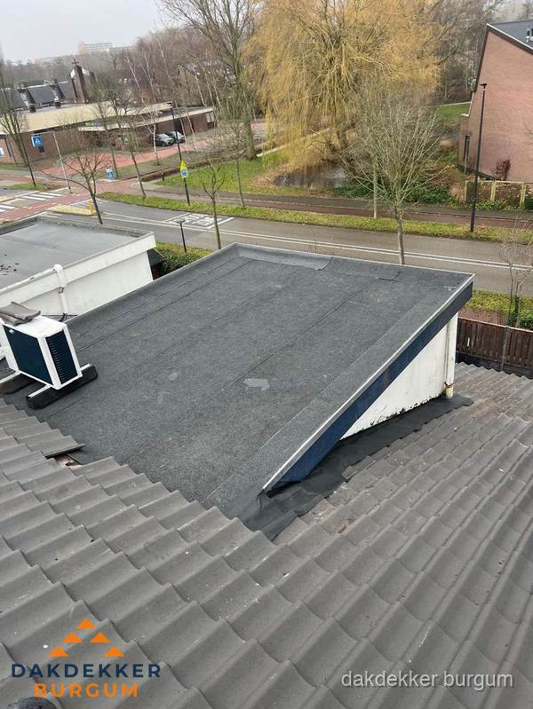 Plat dak met bitumen dakbedekking naast schuin pannendak in Burgum