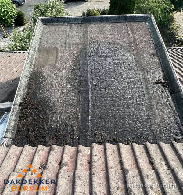 Verouderd plat dak met bitumen en slijtage voor lekkage inspectie in Burgum Verouderd plat dak met bitumen en slijtage voor lekkage inspectie in Burgum