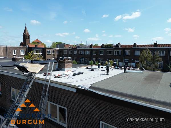 Dakdekkers aan het werk op plat dak in Burgum