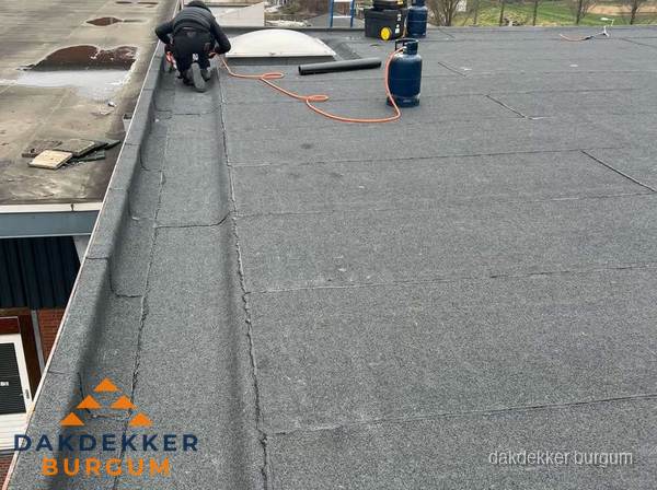 Dakdekker repareert bitumen dakbedekking op groot plat dak in Burgum Dakdekker repareert bitumen dakbedekking op groot plat dak in Burgum