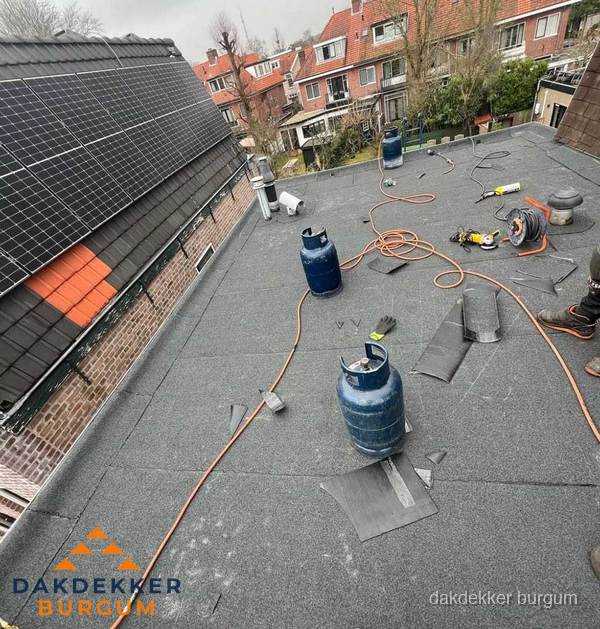 Daklekkage repareren met brandgereedschap op plat dak in Burgum